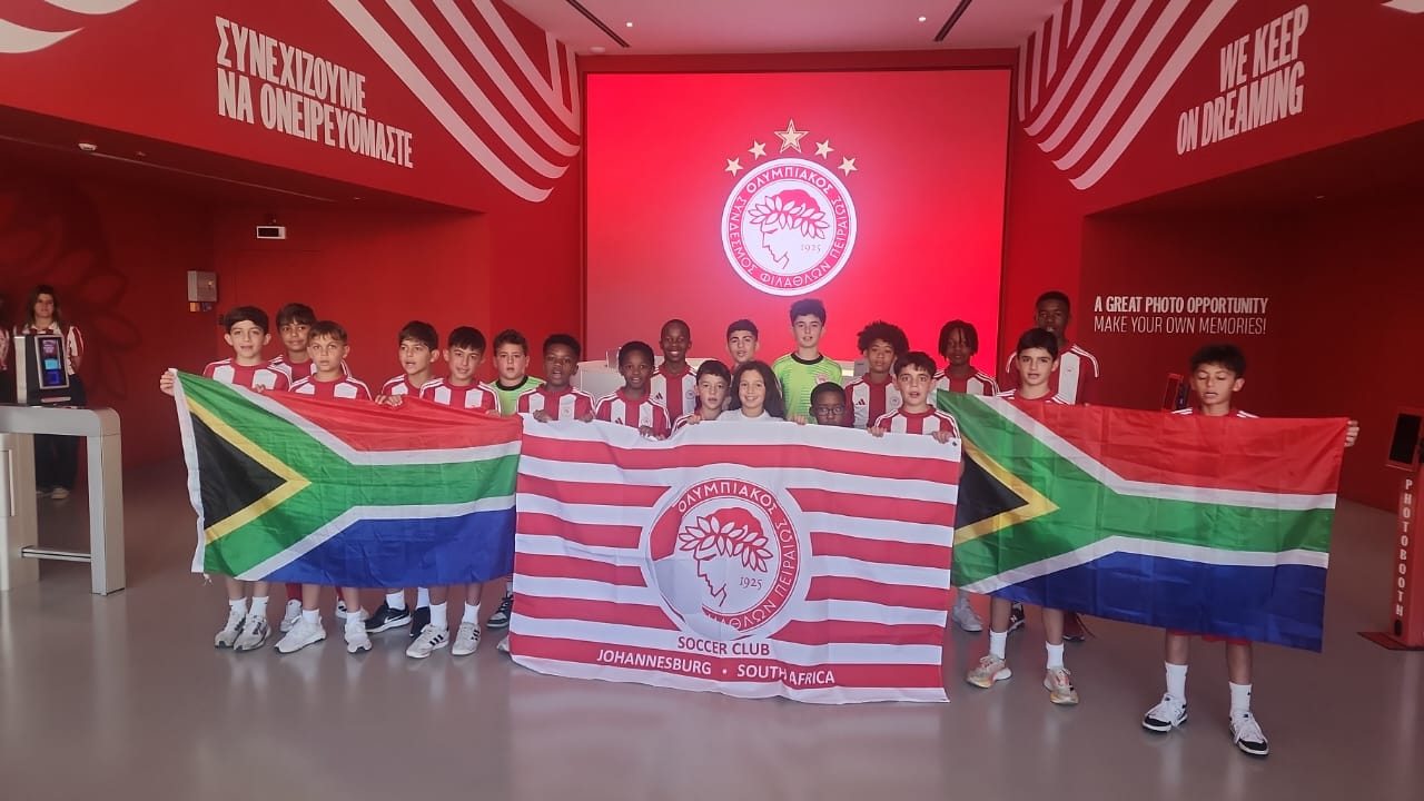 Olympiacos South Africa — youth squad holding SA flags at Olympiacos stadium in Greece